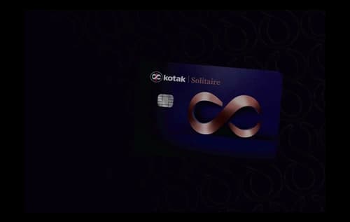 Kotak Solitaire metal credit card on a marble table with a boarding pass